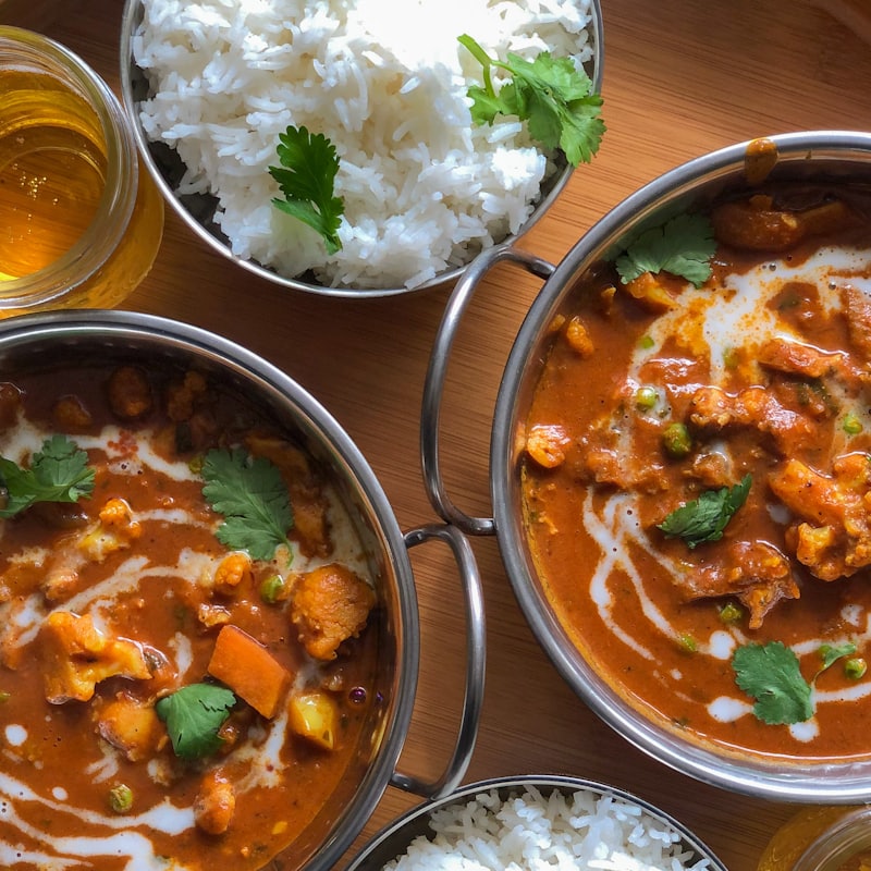 A spread of curries, rice and sides laid out to share