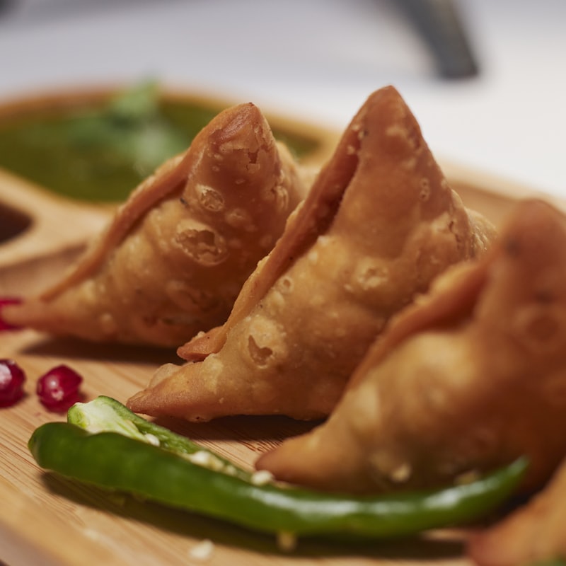 Crisp golden samosas with green chilli and pomegranate